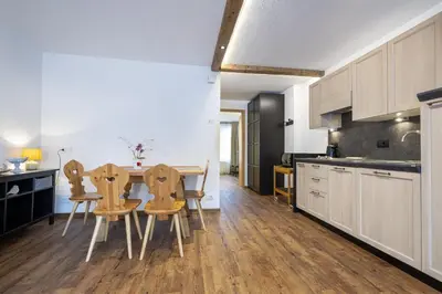 a kitchen with a table and chairs in a room at Apartments No7 Saslong in Ortisei