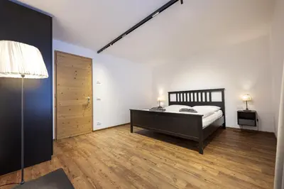 a bedroom with a bed and a wooden floor at Apartments No7 Saslong in Ortisei