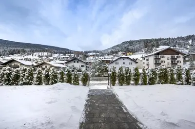 a snow covered city with houses and trees at Apartments No7 Saslong in Ortisei