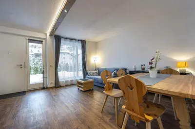 a living room with a table and chairs and a couch at Apartments No7 Saslong in Ortisei