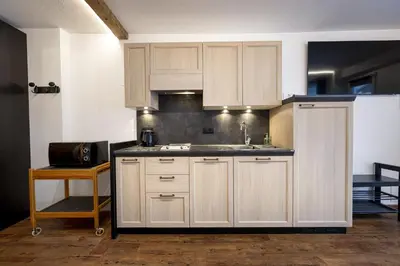 a kitchen with white cabinets and a sink at Apartments No7 Saslong in Ortisei
