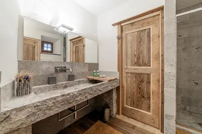 a stone tub with a faucet in a bathroom at Antica Dimora Cotai in Canale dʼAgordo
