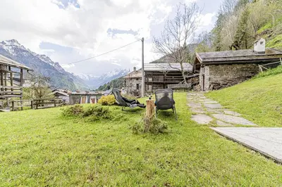 a house with a wooden roof on top of a field at Antica Dimora Cotai in Canale dʼAgordo