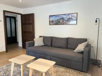 a living room with a couch and two tables at Casa Sasso Bianco in Rocca Pietore