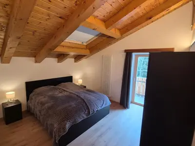a bedroom with a bed and a wooden ceiling at Casa Sasso Bianco in Rocca Pietore
