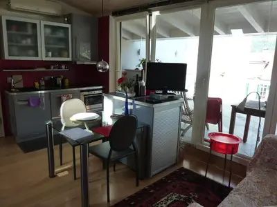 a kitchen with a table with chairs and a television at Apartment Leonardo in Bolzano
