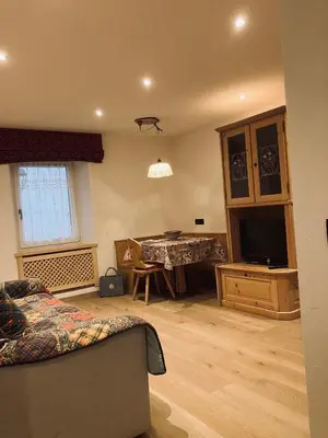 a living room with a couch and a table with a television at CERMIS Minisuite in Cavalese