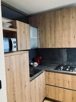 a kitchen with wooden cabinets and a microwave at CERMIS Minisuite in Cavalese