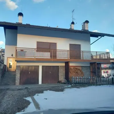 a house with a deck on the side of it at casa elvira in Castello di Fiemme