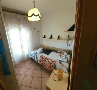 a small bedroom with a bed and a table at casa elvira in Castello di Fiemme