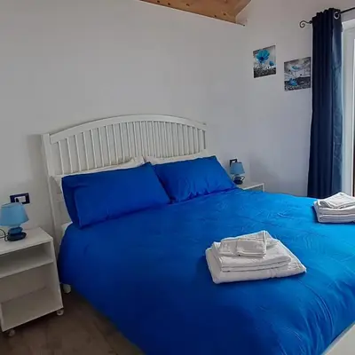 a bedroom with a blue bed with blue pillows at Dream Apartments Moena in Moena