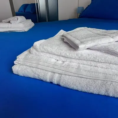 a stack of white towels sitting on a bed at Dream Apartments Moena in Moena
