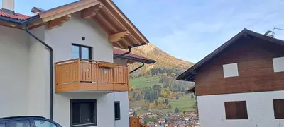 a building with a balcony with a mountain in the background at Dream Apartments Moena in Moena