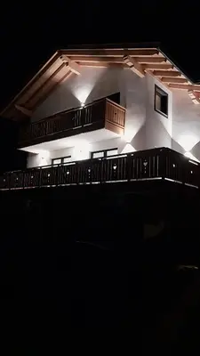 a building with lights on it in the dark at Dream Apartments Moena in Moena