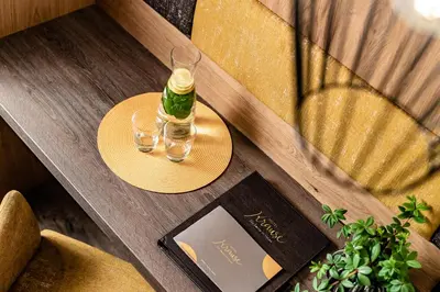 a table with a bottle and two glasses on it at Hotel Krause in Tirolo