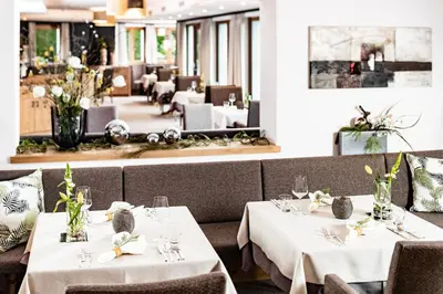a restaurant with two tables with white tablecloths at Hotel Krause in Tirolo