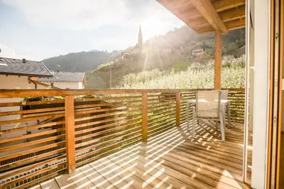 a balcony with a view of a church on a hill at Bachmannhof in Feldthurns