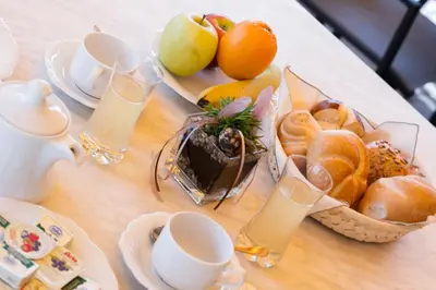 a table with a tray of bread and fruit on it at Gartenheim Ferienwohnung in Caldaro