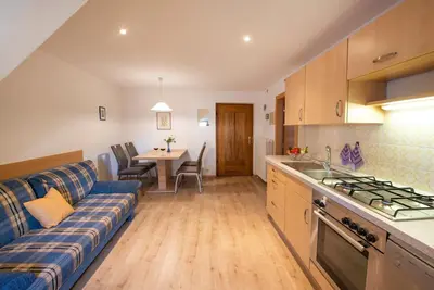 a kitchen and living room with a couch and a table at Gartenheim Ferienwohnung in Caldaro