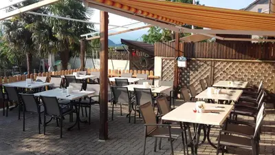 an outdoor dining area with tables and chairs at Gartenheim Ferienwohnung in Caldaro