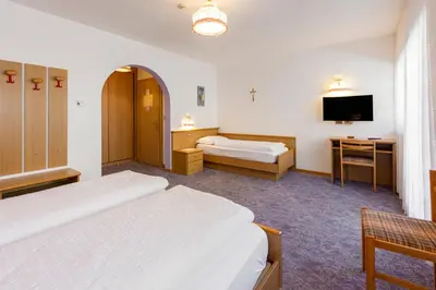 a bedroom with a bed with two white pillows at Hotel Villa Jolanda in Ziano di Fiemme