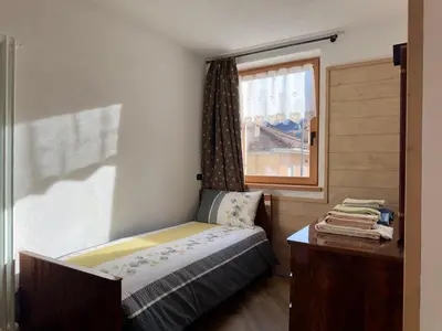 a small bedroom with a bed and a window at Appartamenti LITEGOSA casa vacanza 3 in Panchia