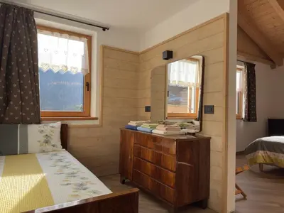 a bedroom with a bed and a dresser and a mirror at Appartamenti LITEGOSA casa vacanza 3 in Panchia