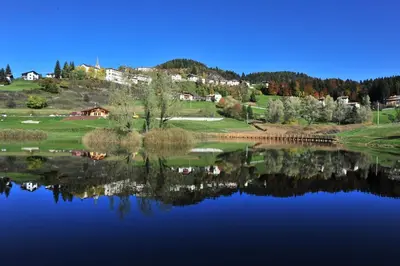 a view of a lake with houses in the background at Appartamenti Agritur Mas da la Val in Ronzone