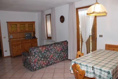 a living room with a table and a couch at Appartamenti Agritur Mas da la Val in Ronzone
