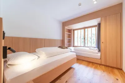 two beds in a room with a window at Linara Mountain Family Stay in Valles