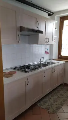a white kitchen with a sink and a stove at Casa Vacanze Fontana in Coredo