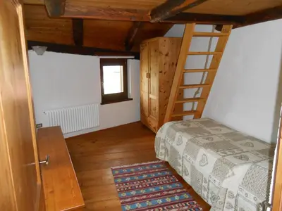 a bedroom with a bunk bed and a ladder at Casa Vacanze Fontana in Coredo
