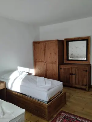 a bedroom with a bed with a wooden headboard at Villa Ronco - Stayincortina in Cortina dʼAmpezzo