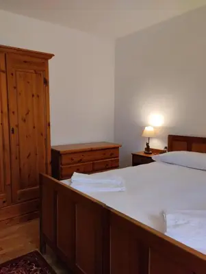 a bedroom with a bed and a dresser at Villa Ronco - Stayincortina in Cortina dʼAmpezzo