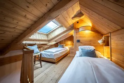 an attic bedroom with two beds and a window at Attic Apartment Dolasilla in Selva di Val Gardena