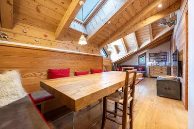a dining room with a large wooden table and chairs at Attic Apartment Dolasilla in Selva di Val Gardena