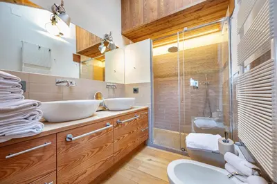 a bathroom with two sinks and a glass shower at Attic Apartment Dolasilla in Selva di Val Gardena