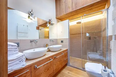 a bathroom with two sinks and a shower at Attic Apartment Dolasilla in Selva di Val Gardena