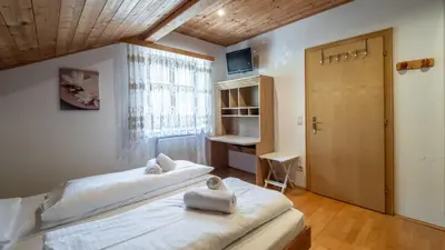 two beds in a room with a window at Ferienwohnung Bergblick in Termeno