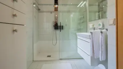 a white bathroom with a shower and a sink at Ferienwohnung Bergblick in Termeno