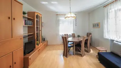 a dining room with a table and chairs and a television at Ferienwohnung Bergblick in Termeno