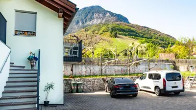a white car parked next to a building with a mountain at Ferienwohnung Bergblick in Termeno