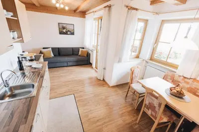 a kitchen and living room with a couch and a table at Weißhaus Hof in Caldaro