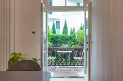 an open door to a balcony with a table and chairs at Frida's apartment in Merano
