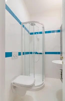 a bathroom with a shower with a toilet and a sink at Frida's apartment in Merano