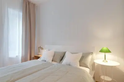 a bedroom with a large bed with a green lamp at Frida's apartment in Merano