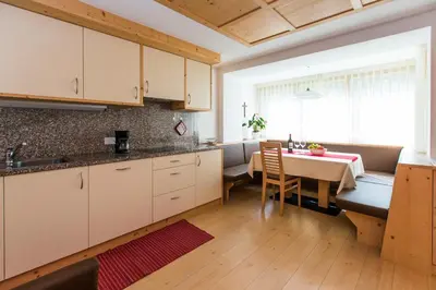 a kitchen with a table and a dining room at Appartamenti Genziana in La Villa