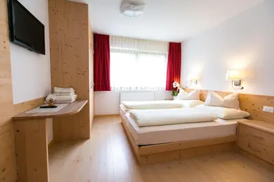 a bedroom with a large bed and a window at Appartamenti Genziana in La Villa