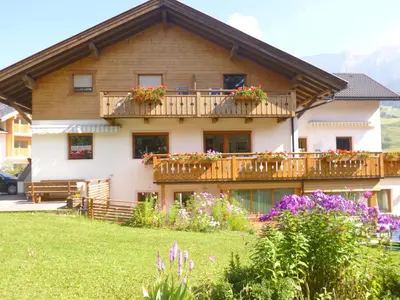 a house with a balcony with flowers on it at Appartamenti Genziana in La Villa