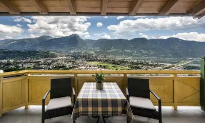 a table and chairs on a balcony with a view at Hotel Restaurant Waldea in Marlengo